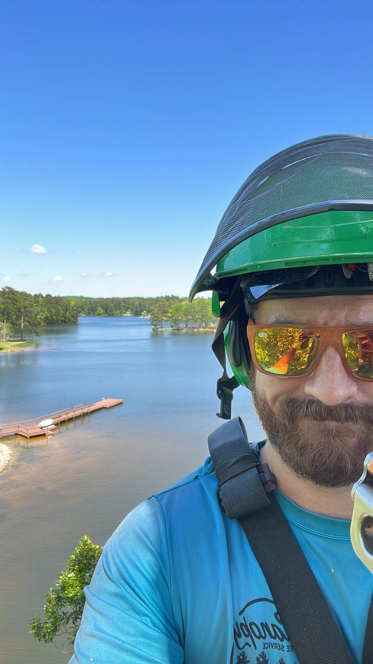 Crane truck grappling cut tree sections in residential neighborhood